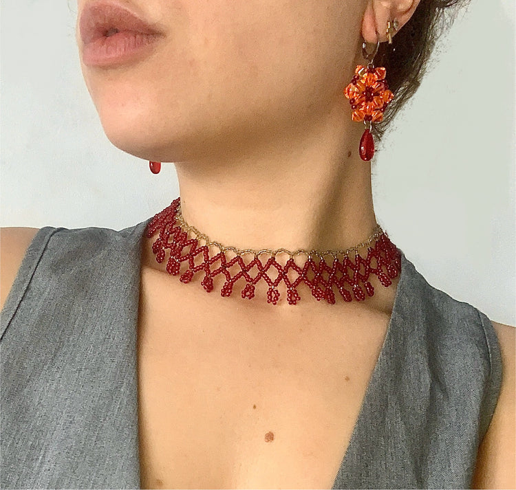 Pendientes de acero inoxidable y cuentas artesanales en exhibición sobre fondo neutro