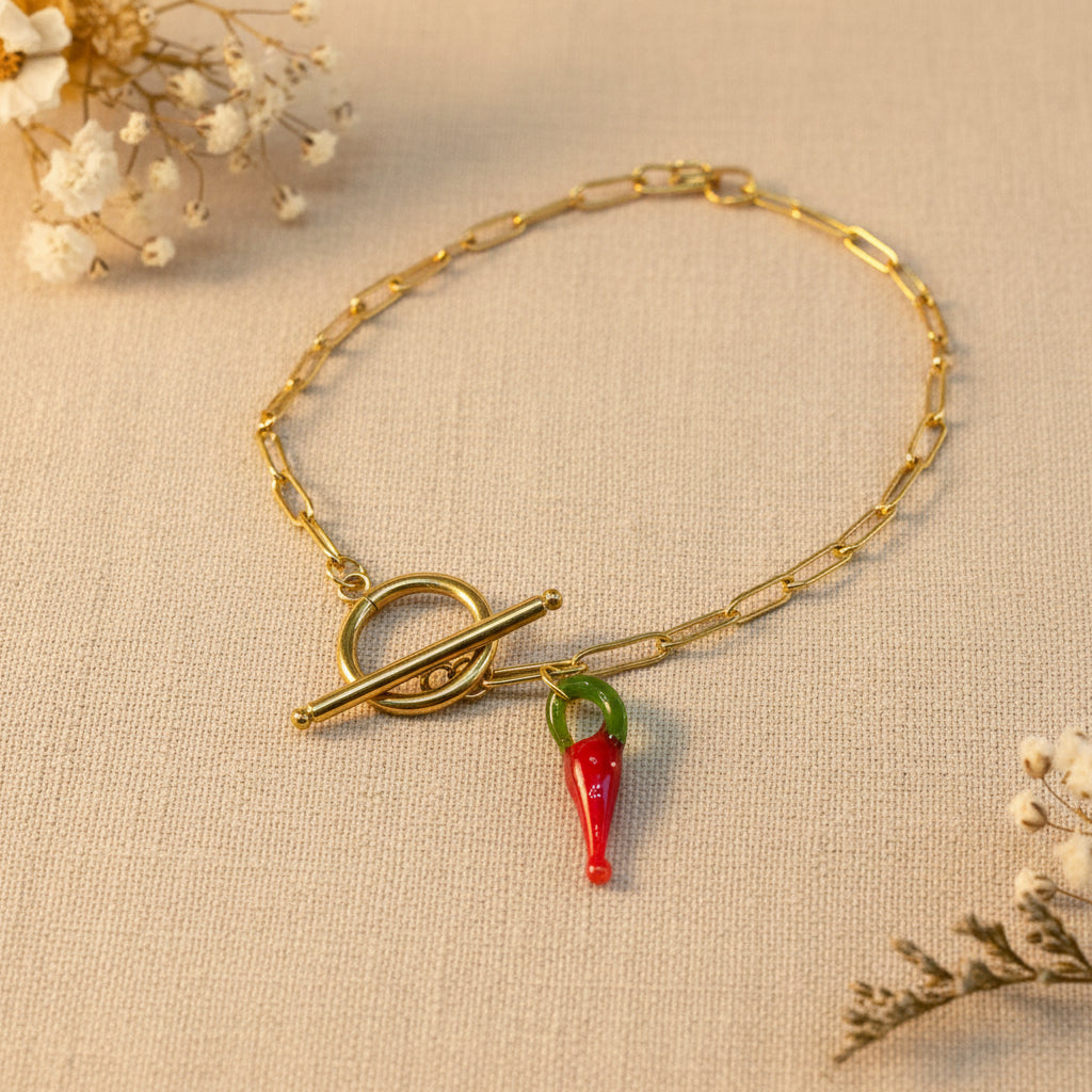 Collar Chili con cadena dorada de acero inoxidable y colgante artesanal de vidrio rojo en forma de jalapeño cerca