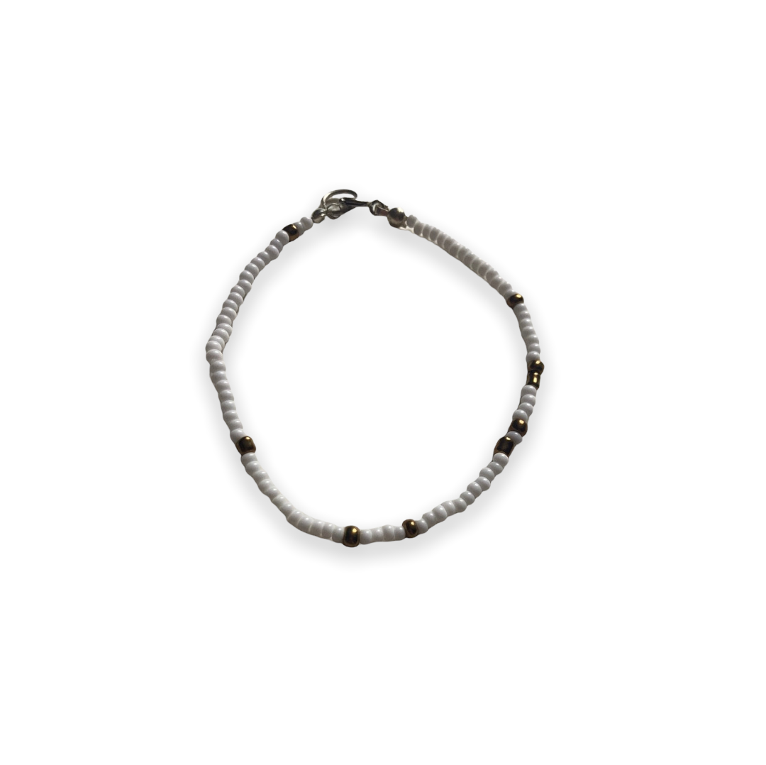 Pulsera de cristal con cuentas blancas y marrón dorado sobre hilo elástico