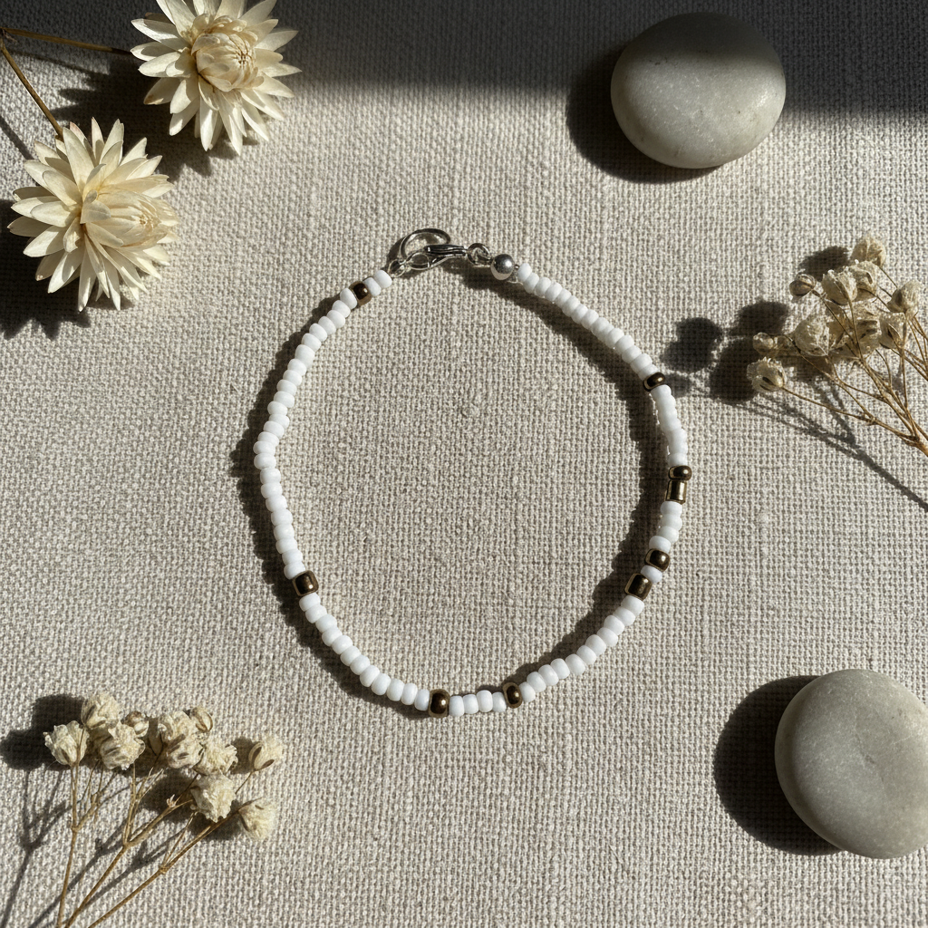 Pulsera de cristal con cuentas blancas y marrón dorado sobre hilo elástico