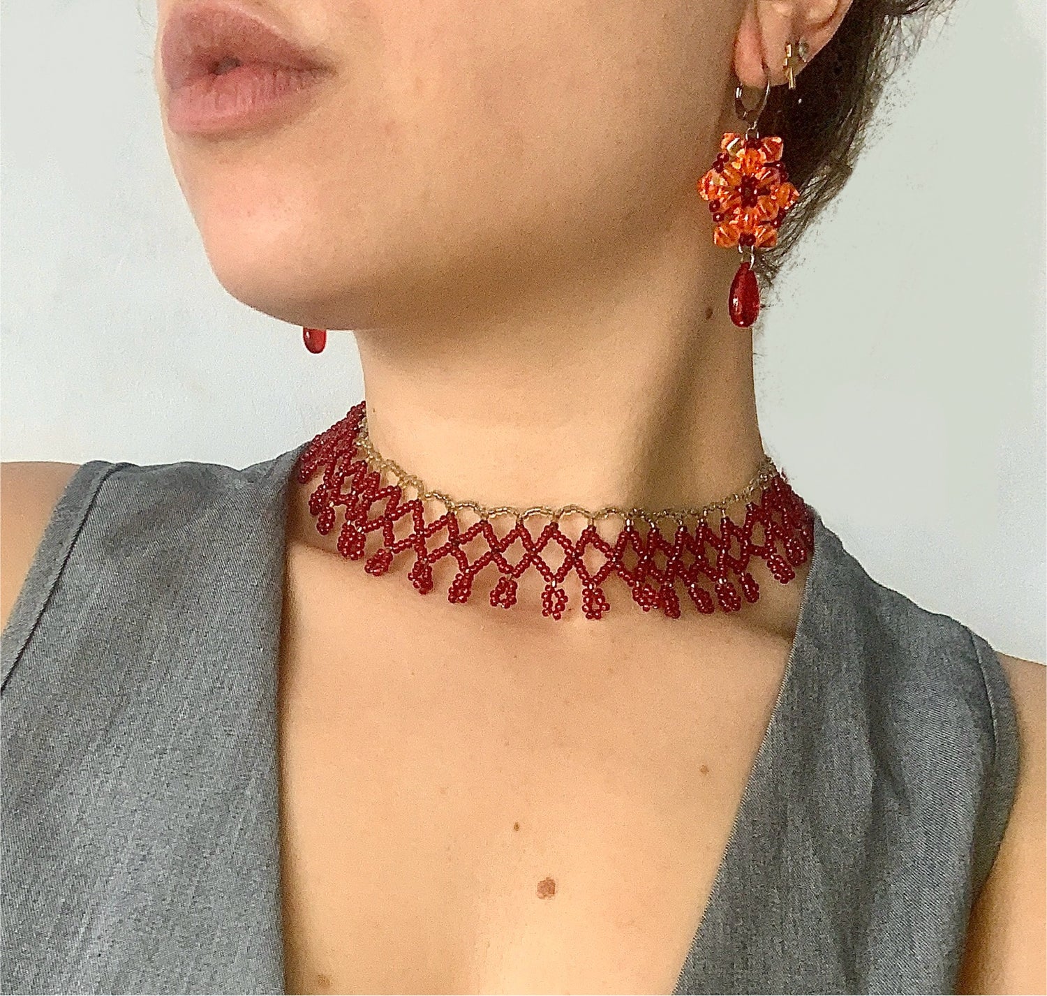 Pendientes de acero inoxidable y cuentas artesanales en exhibición sobre fondo neutro
