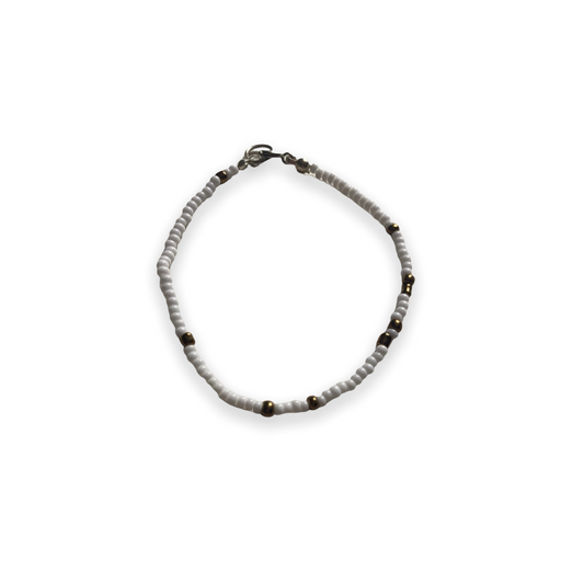 Pulsera de cristal con cuentas blancas y marrón dorado sobre hilo elástico